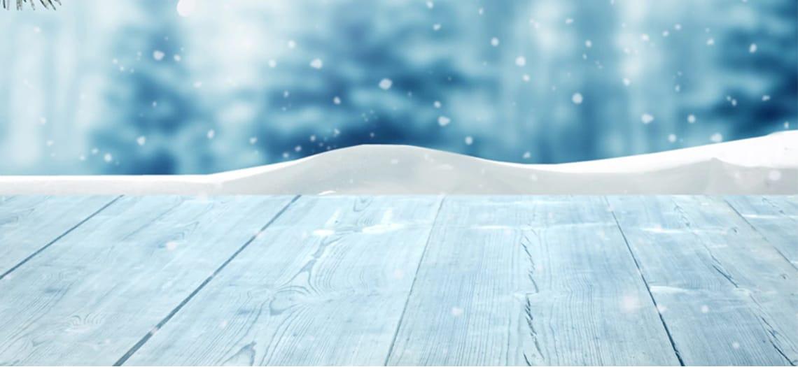 Sneeuw op lichtblauwgrijze houten planken
